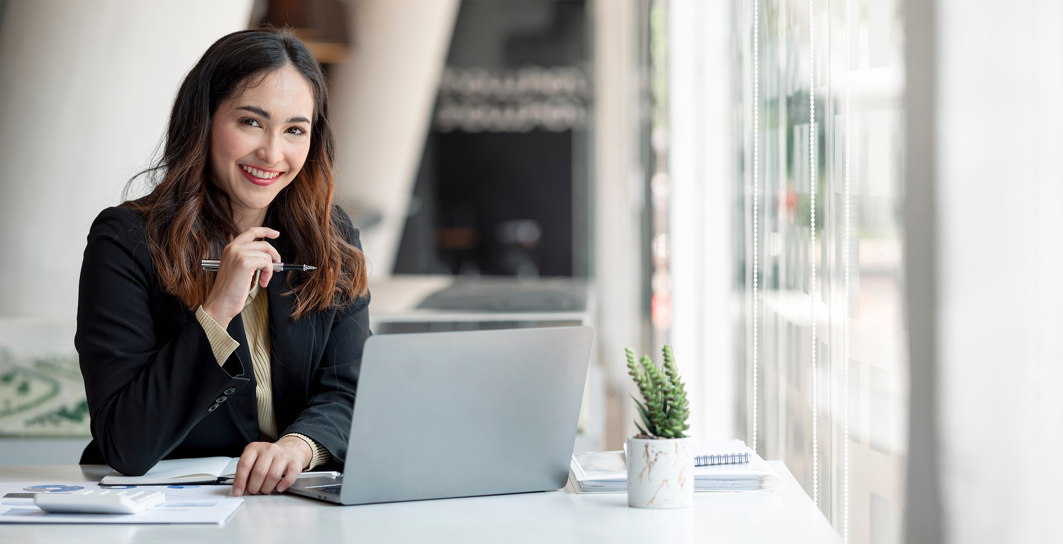 Woman Sitting at a Work Area with a Laptop 